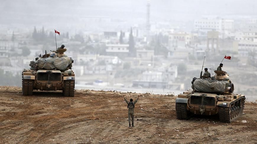 Turkish army tanks take position on top of a hill near Mursitpinar border crossing in the southeastern Turkish town of Suruc in Sanliurfa province October 11, 2014. A senior Kurdish militant has threatened Turkey with a new Kurdish revolt if it sticks with its current policy of non-intervention in the battle for the Syrian town of Kobani. Kurdish forces allied to the Kurdistan Workers' Party (PKK), the People's Defence Units (YPG), are fighting against Islamic State insurgents attacking Kobani close to the 