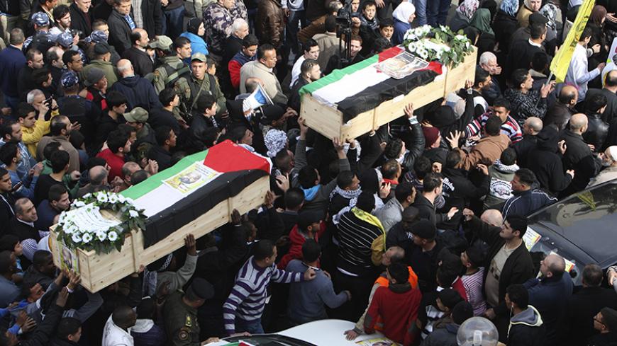 Palestinians carry coffins containing the remains of Palestinian militants Fathi Ameereh (R) and Ata Samahneh during their funeral in the West Bank city of Nablus January 22, 2014. Israel begun to exhume the remains of a number of Palestinian militants, including Ameereh and Samahneh, to return them to their families for burial, the army said on Sunday, a move that could help ease some tension between the adversaries. REUTERS/Abed Omar Qusini (WEST BANK - Tags: POLITICS CIVIL UNREST OBITUARY) - RTX17PKK