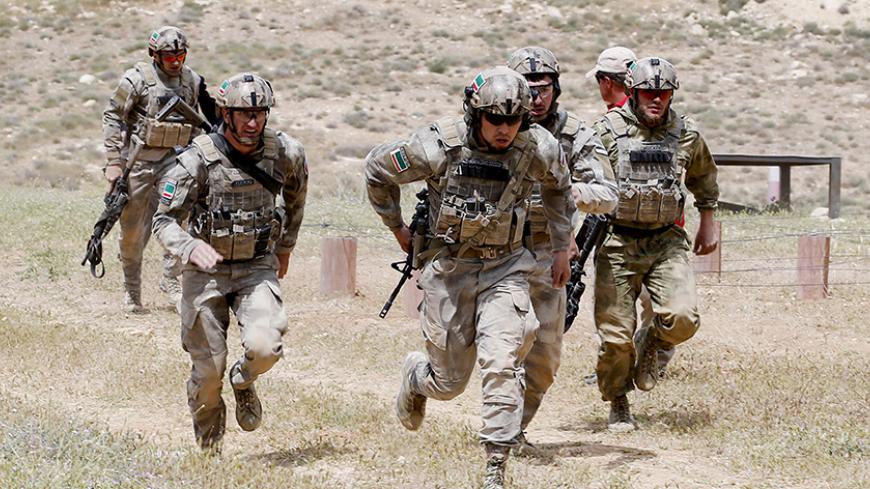 Chechen soldiers, representing Russia and wearing uniforms stitched with Chechen flags, compete in the 7th Annual Warrior Competition at the King Abdullah Special Operations Training Center in Amman April 22, 2015. Thirty-eight teams from 18 countries are participating in the competition to test their military skills. REUTERS/Muhammad Hamed - RTX19UI0