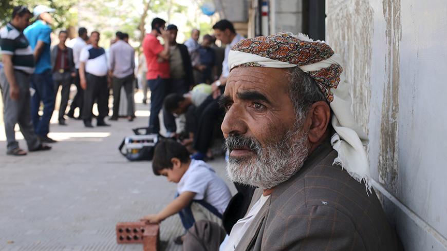 Yemenis, hoping to obtain a flight ticket back to Yemen, wait outside a branch office of Yemenia Airways after being stranded in Cairo, April 28, 2015.  At least 15 people were killed in heavy fighting between Houthi fighters and tribesmen in the oil-producing Marib province in central Yemen, tribal and medical sources said on Tuesday, as Saudi-led air strikes against the Iran-allied militia continued. REUTERS/Asmaa Waguih - RTX1AND4