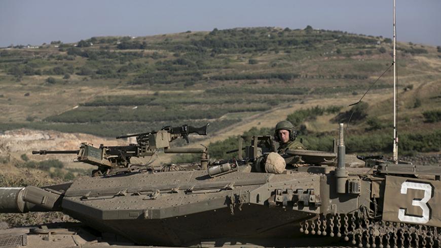 An Israeli soldier rides a tank on the Israeli side of the border fence between Syria and the Israeli-occupied Golan Heights, near Majdal Shams, June 16, 2015. Israel's president expressed his concern to the United States last week about the fate of the Druze minority in Syria, saying around 500,000 of them were under threat from Islamist militants in an area near the Israeli border. REUTERS/Baz Ratner - RTX1GRYM