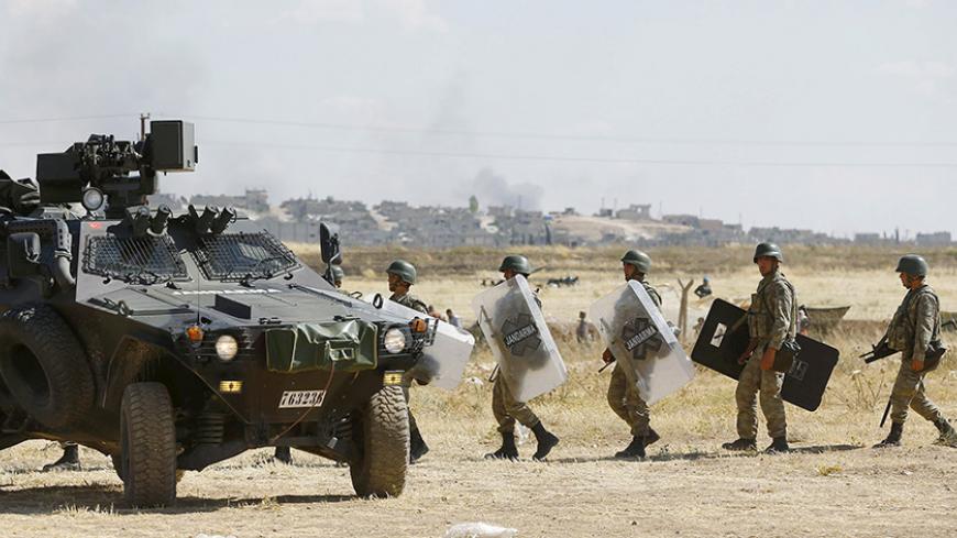 Turkish soldiers stand guard near the Mursitpinar border gate in Suruc, bordering with the northern Kurdish town of Kobani, in Sanliurfa province, Turkey, June 26, 2015. Islamic State fighters killed at least 145 civilians in an attack on the Syrian town of Kobani and a nearby village, in what a monitoring group described on Friday as the second worst massacre carried out by the hardline group in Syria. Fighting between the Kurdish YPG militia and Islamic State fighters who infiltrated the town at the Turki
