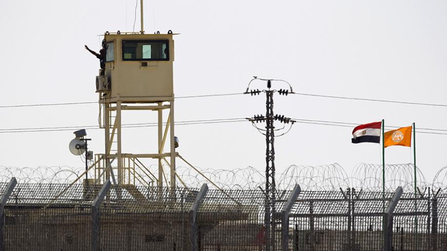 A member of Egypt's security forces gestures as he stands on a watchtower in North Sinai as seen from across the border in southern Israel July 2, 2015. Egypt launched air strikes on Islamist militant targets in the Sinai peninsula on Thursday, killing 23 fighters a day after the deadliest clashes in the region in years, security sources said. The sources said those killed had taken part in Wednesday's fighting in which 100 militants and 17 soldiers, including four officers, were killed, according to the ar