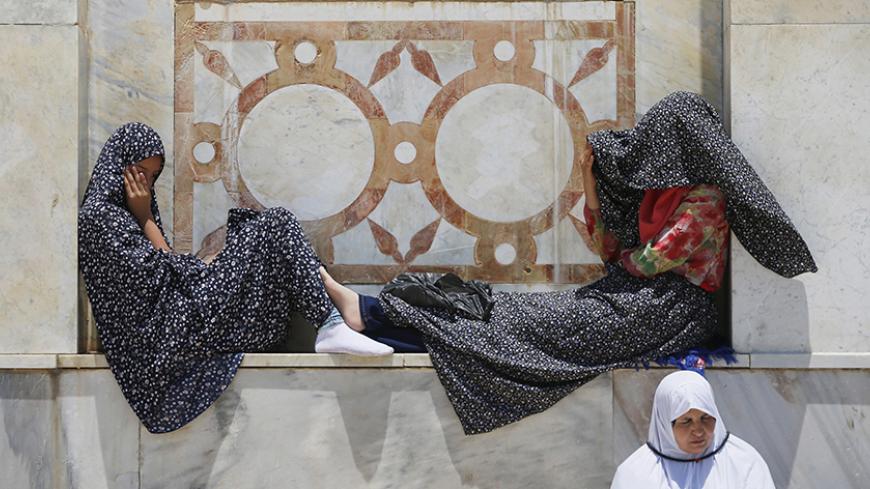 Palestinian women wait ahead of prayers on the third Friday of the holy month of Ramadan at the compound known to Muslims as the Noble Sanctuary and to Jews as Temple Mount, in Jerusalem's Old City July 3, 2015. An Israeli police spokesperson said on Friday that some 150,000 people attended the prayers on the compound and Israel barred Palestinian men under 50 and women under 30 from entering Jerusalem from the West Bank without a permit. REUTERS/Ammar Awad - RTX1IWTP