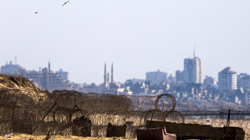 Barbed wire is seen on Zikim beach, Israel near the border with northern Gaza (seen in background) July 9, 2015. Two Israeli citizens are being held by Hamas in the Gaza Strip, Prime Minister Benjamin Netanyahu said on Thursday, a situation that could lead to demands for a prisoner exchange between Israel and the Islamist militant group. Hamas, which took control of the Palestinian coastal enclave in 2007 and fought three wars with Israel since then, declined to confirm or deny it had the captives. REUTERS