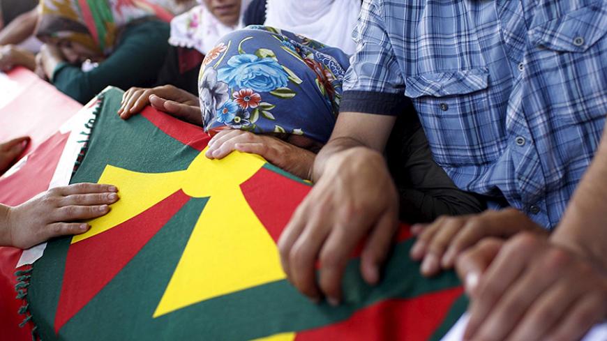 Relatives of victims who were killed in Monday's bomb attack in Suruc mourn over the coffins at a cemetery in Gaziantep, Turkey, July 21, 2015. Turkey's Prime Minister Ahmet Davutoglu rejected accusations Turkey had in the past tacitly supported Islamic State militants operating from Syria and unwittingly opened the door to a suicide bombing that killed at least 32 people. The blast on Monday tore through a group of university-aged students from an activist group as they gathered in the border town of Suruc