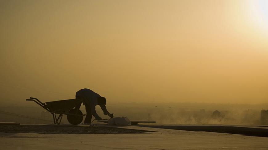 EDITORS' NOTE:  Reuters and other foreign media are subject to Iranian restrictions on their ability to film or take pictures in Tehran.

The sun sets as a labourer works on the grounds of Tehran's Milad Tower October 19, 2010. Picture taken October 19. REUTERS/Caren Firouz  (IRAN - Tags: CITYSCAPE EMPLOYMENT BUSINESS) - RTXTMW5