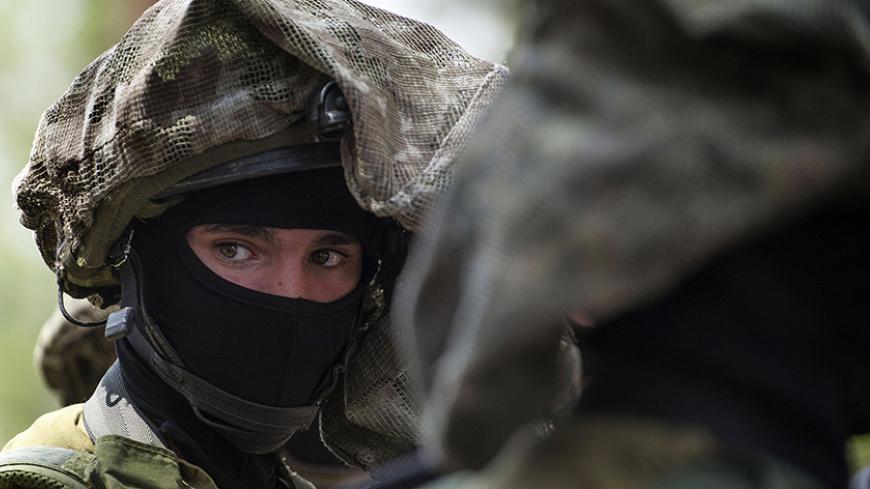 An Israeli special forces member looks on during a visit by U.S. Defense Secretary Chuck Hagel (not pictured) to a military K-9 unit training site at an army base near Tel Aviv April 23, 2013. REUTERS/Jim Watson/Pool (ISRAEL - Tags: POLITICS MILITARY) - RTXYWQZ