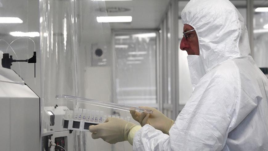 A scientist works at the International Atomic Energy Agency (IAEA) environmental sample laboratory in Seibersdorf April 24, 2013. The self-styled "Sherlock Holmeses" of the U.N. nuclear watchdog, now seeking access to a major Iranian base, say they have the capability to find tiny traces of atomic material at a site even if a country were to try to cover it up. Picture taken April 24, 2013. TO GO WITH STORY NUCLEAR-IAEA/LABORATORY  REUTERS/Heinz-Peter Bader  (AUSTRIA - Tags: POLITICS ENERGY SCIENCE TECHNOLO