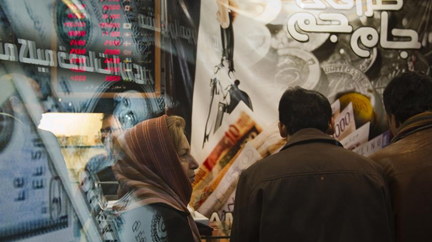 EDITORS' NOTE: Reuters and other foreign media are subject to Iranian restrictions on leaving the office to report, film or take pictures in Tehran.

An Iranian woman stands in a currency exchange shop in northern Tehran January 3, 2012. The Iranian rial fell to a record low against the dollar on Tuesday following U.S. President Barack Obama signing a bill on  imposing fresh sanctions against the country's central bank.    REUTERS/Morteza Nikoubazl (IRAN - Tags: BUSINESS POLITICS) - RTR2VU75