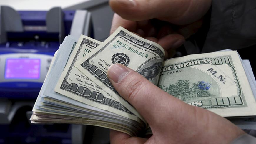 A money changer counts U.S. dollar bills at a currency exchange office in central Istanbul April 15, 2015. Turkish Economy Minister Nihat Zeybekci said on Wednesday the lira's slide to record lows was not a cause for concern and reflected global developments, arguing against forex intervention and saying the currency will find its own balance. He also told a meeting in Istanbul that he expected first quarter year-on-year growth of around 1.5 percent, and full year growth exceeding last year's 2.9 percent. R