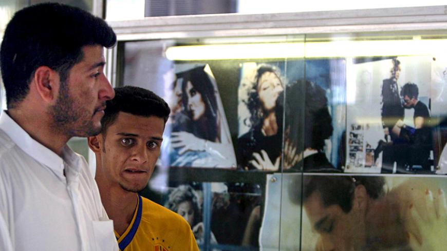 Iraqi men walk past posters advertising a pornographic film at a cinema
in Baghdad, April 30, 2003. Pornography and prostitution was officially
banned under the regime of Saddam Hussein until his ousting from power
by U.S.-led forces two weeks ago.

REUTERS/Zohra Bensemra - RTRMOD7