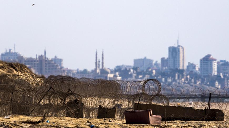 Barbed wire is seen on Zikim beach, Israel near the border with northern Gaza (seen in background) July 9, 2015.  Two Israeli citizens are being held by Hamas in the Gaza Strip, Prime Minister Benjamin Netanyahu said on Thursday, a situation that could lead to demands for a prisoner exchange between Israel and the Islamist militant group. Hamas, which took control of the Palestinian coastal enclave in 2007 and fought three wars with Israel since then, declined to confirm or deny it had the captives. REUTERS