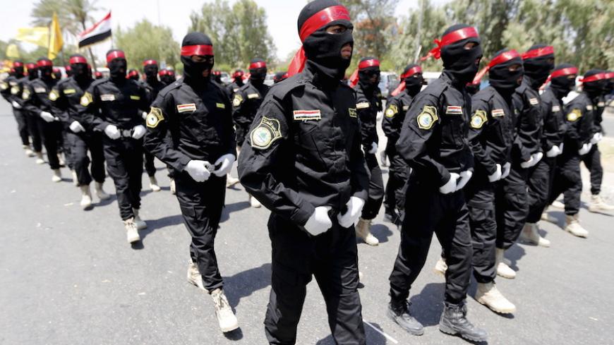 Iraqi Shiite Muslim men from Hashid Shaabi (Popular Mobilization) march during a parade marking the annual al-Quds Day, or Jerusalem Day, on the last Friday of the Muslim holy month of Ramadan in Baghdad, July 10, 2015. REUTERS/Thaier al-Sudani  - RTX1JV9P