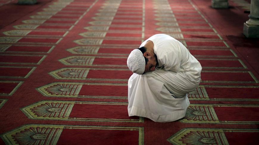 A man attends an evening prayer during Ramadan at Al-Azhar Mosque in the old Islamic area of Cairo, Egypt July 10, 2015. REUTERS/Amr Abdallah Dalsh - RTX1KDLO