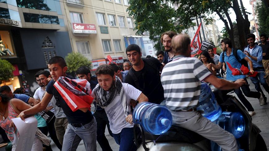 Demonstrators run away from riot police during protests against Monday's bomb attack in Suruc, in Istanbul, Turkey, July 24, 2015. REUTERS/Yagiz Karahan - RTX1LPYT