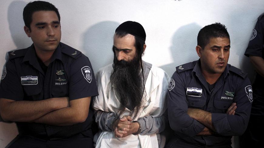 Yishai Schlissel (C) is escorted by security personnel at the Jerusalem Magistrates Court July 31, 2015. Schlissel is suspected of stabbing and wounding six participants at a Gay Pride parade in Jerusalem on Thursday. REUTERS/Muammar Awad - RTX1MITX
