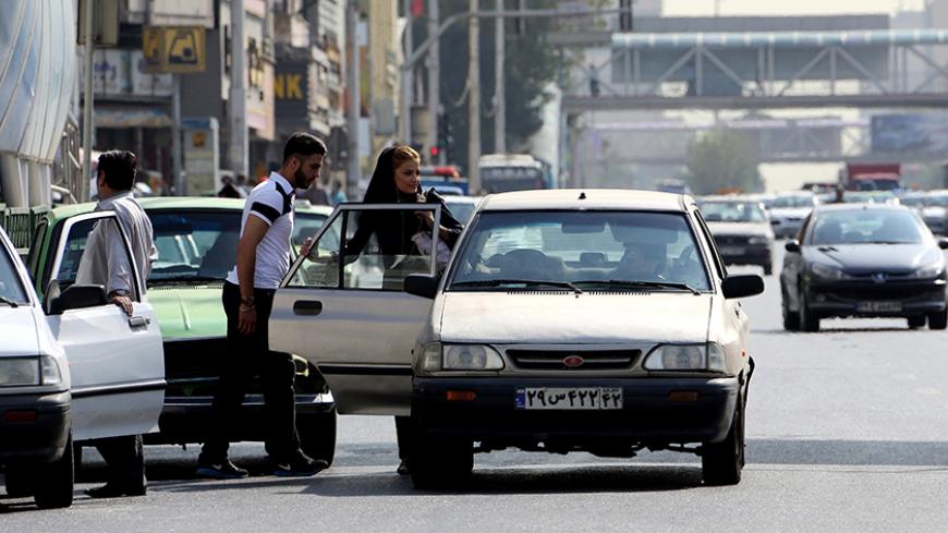 TO GO WITH AFP STORY BY ALI NOORANI - A picture taken on September 12, 2015 shows an Iranian couple getting into a Pride car (manufactured by SAIPA Iranian auto manufacturer) in northern Tehran. A campaign to boycott "substandard and expensive" Iranian-made cars has fired up social media in the Islamic republic, where its supporters have been accused of anti-revolutionary treason.   AFP PHOTO / ATTA KENARE        (Photo credit should read ATTA KENARE/AFP/Getty Images)