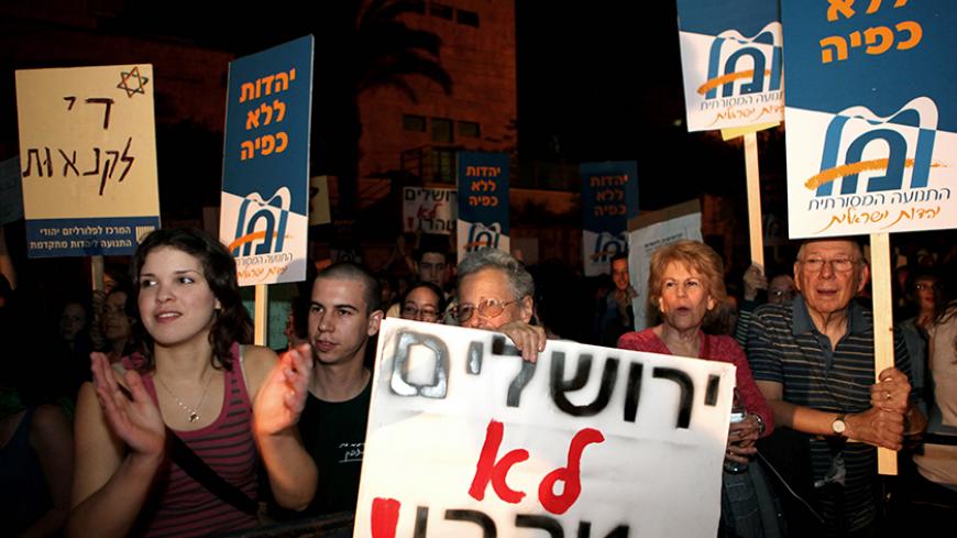 Hundreds of secular Israelis and reform Jews demonstrate in Jerusalem on March 13, 2010 against waht they call ultra-Orthodox Jewish religious oppression and the gender-segregated buses in certain conservative areas in Jerusalem where women are forced to sit in the back of the bus. The protestors are carrying signs reading "Israel is not Tehran," in reference to the Iranian capital where strict Islamic rules force women to wear the veil in public. AFP PHOTO/GALI TIBBON (Photo credit should read GALI TIBBON