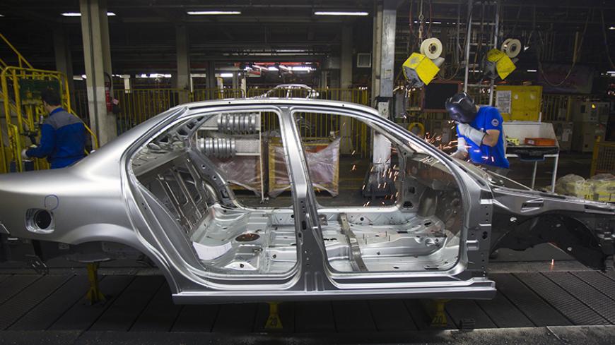 An Iranian worker works on a production line of carmaker Iran Khodro, west of Tehran June 20, 2011.  Unusually for the Middle East, Iran has developed its domestic car industry for five decades and produced 1.6 million vehicles last year, about half of them made by Iran Khodro which aims to export around 10 percent of its production this year. Even with sanctions, which have scared off some suppliers from exporting to Iran, and a limp economy, Iran Khodro says sales rose 18 percent in 2010 and plans a 13 pe