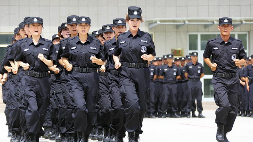 Policewomen from Special Weapons and Tactics (SWAT) team run in formation during a graduation performance after training as members of an anti-terrorist patrol team, in Hami, Xinjiang Uighur Autonomous Region June 29, 2014. Picture taken June 29, 2014. REUTERS/China Daily (CHINA - Tags: MILITARY CRIME LAW) CHINA OUT. NO COMMERCIAL OR EDITORIAL SALES IN CHINA - RTR3WKJW