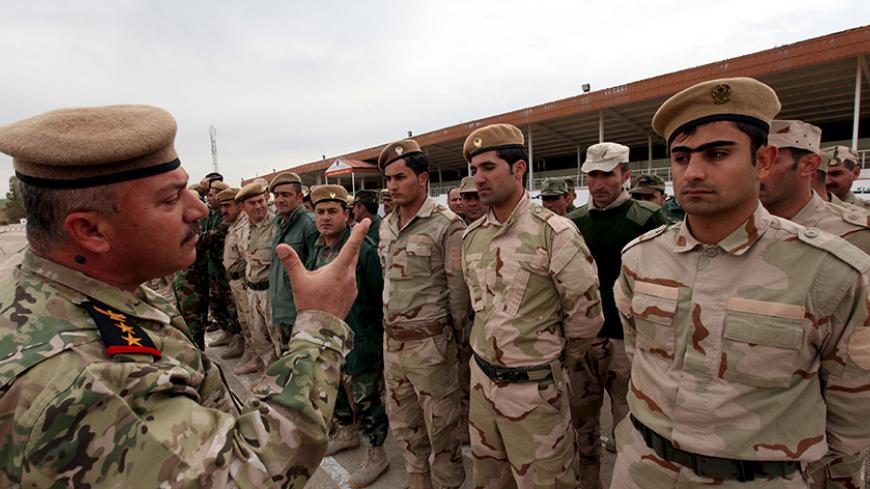 An officer speaks to Kurdish Peshmerga forces during a training session by coalition forces on how to fight street battles and defend the front lines in a training camp in the outskirts of Arbil, north of Iraq, March 24, 2015. REUTERS/Azad Lashkari - RTR4UN6E