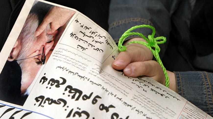An Iranian journalist in symbolic rope shackle holds a copy of a banned reformist newspaper at a protest gathering in Tehran, July 26, 2004. More than 100 journalists gathered to protest against what they think is a fresh round of press crackdown in Iran. REUTERS/Raheb Homavandi  AP/DBP - RTR7D7P
