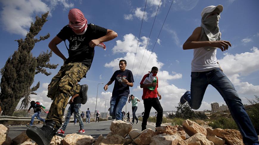 Palestinian protesters run during clashes with Israeli troops over tension in Jerusalem's al-Aqsa mosque, near the occupied West Bank city of Ramallah September 29, 2015. Israeli police and Palestinians clashed on Sunday at Jerusalem's al-Aqsa mosque compound, where violence in recent weeks has raised international concern. REUTERS/Mohamad Torokman TPX IMAGES OF THE DAY - RTS29AG