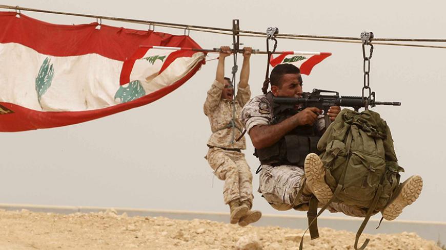 Members of the Lebanese Army's airborne regiment perform a live drill, held as part of a weapons exhibition during the Security Middle East Show in Beirut, as a sandstorm engulfed Lebanon for a second day September 9, 2015. REUTERS/Mohamed Azakir - RTSBDO
