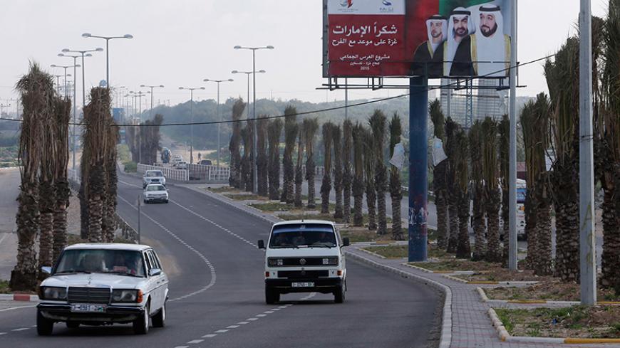 Palestinians drive past a billboard with pictures depicting UAE President Sheikh Khalifa bin Zayed al-Nahayan (R), Abu Dhabi Crown Prince Sheikh Mohammed bin Zayed (C) and UAE Deputy Prime Minister Sheikh Mansour bin Zayed al-Nahyan in Gaza City March 15, 2015. The billboard reads, "Thanks Emirates. Gaza is on a date for celebration. Mass wedding project."
REUTERS/Ibraheem Abu Mustafa (GAZA - Tags: SOCIETY POLITICS) - RTR4TEDA