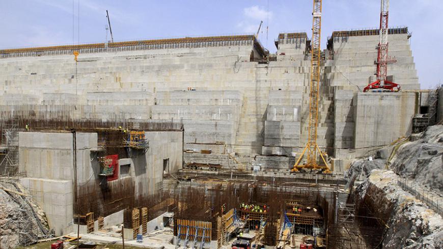 Construction workers are seen at a distance in a section of Ethiopia's Grand Renaissance Dam, as it undergoes construction, during a media tour along the river Nile in Benishangul Gumuz Region, Guba Woreda, in Ethiopia March 31, 2015. According to a government official, the dam has hit the 41 percent completion mark. Picture taken March 31, 2015. REUTER/Tiksa Negeri   - RTR4VQ5E