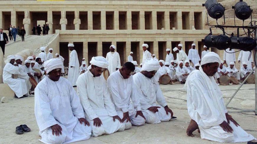 Members of a Nubian folk group perform a prayer December 10 in front of the ancient temple of Queen Hatshepsut in Luxor. In a bid to clean up all signs of the grisley killing of 58 foreign tourists by Moslem militants last month, Egypt held an obituary ceremony at Luxors Hatshepsut temple, the site of the massacre.

EGYPT TOURIST MEMORIAL - RTR9IRM