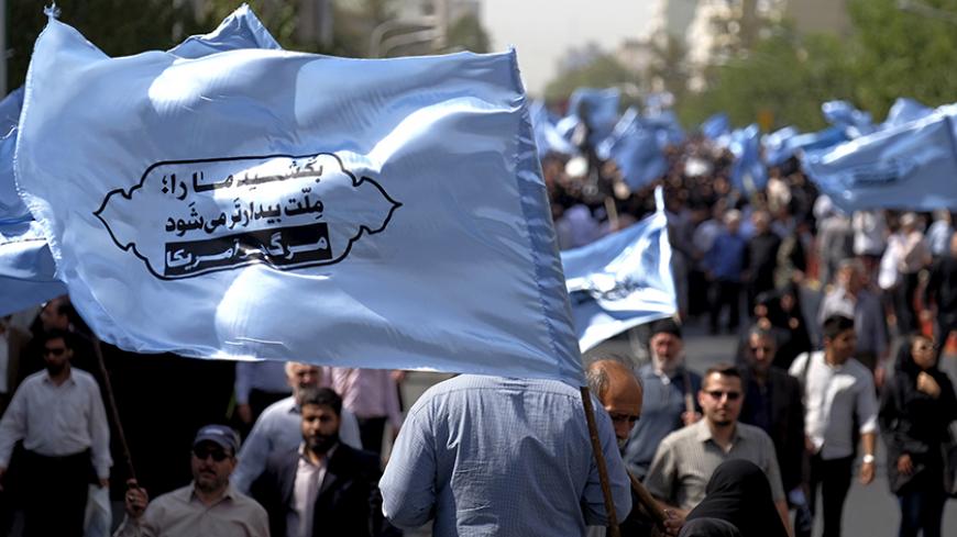 Mourners attend the funeral of victims killed in Saudi Arabia during a stampede at the haj pilgrimage, in Tehran October 4, 2015. More than 464 Iranian nationals were killed in last month's crush in Mina, Saudi Arabia, Iran's Haj Organization says. Iranian officials have alleged the overall total death toll is more than 1,000. Saudi Arabia has confirmed the deaths of 769 people. The banner reads, "Kill our nation, our nation becomes more awake. Down with the U.S."REUTERS/Raheb Homavandi/TIMAATTENTION EDITOR