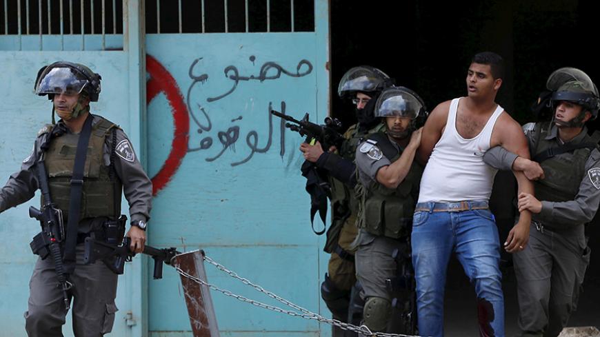 Israeli border policemen detain a wounded Palestinian protester who witnesses said was shot by the troops during clashes following a rally ahead of the Nakba day in the West Bank city of Bethlehem May 14, 2015. Palestinians mark "Nakba" (Catastrophe) on May 15 to commemorate the expulsion or fleeing of some 700,000 Palestinians from their homes in the war that led to the founding of Israel in 1948. REUTERS/Ammar Awad TPX IMAGES OF THE DAY - RTX1CYIX