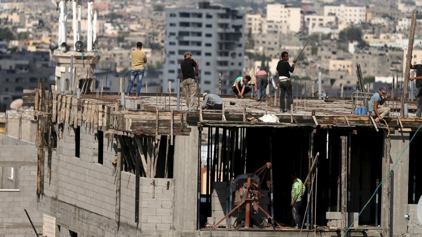 Workers rebuild a Palestinian house that was completely destroyed in last year's 50-day war between Israel and Palestinian militant groups in Gaza Strip, November 8, 2015. The house among the first number of houses to be rebuilt since the war ended. Palestinian and United Nations officials said nearly 130,000 houses were either destroyed or damaged during the war. REUTERS/Mohammed Salem  - RTS606Q