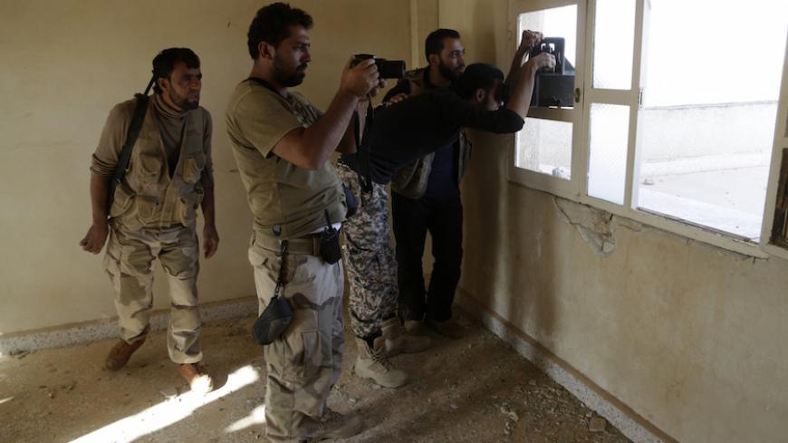 Free Syrian Army fighters of the 101 Division, monitor the movements of the forces loyal to Syria's President Bashar al-Assad near al-Tamana town in the southern countryside of Idlib, Syria October 14, 2015. Fares al-Bayoush, a former Syrian army colonel who heads the Fursan al-Haq group, spoke of a battery of TOW missile platforms stretching east along the frontline from Kafr Nabuda to the village of Maan. The aim is to stop government forces advancing north from Morek to rebel-held Khan Shaykhoun, both to