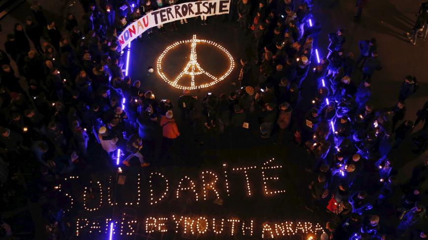 People gather around candles during a ceremony for the victims the day after a series of deadly attacks in the French capital of Paris, in Lausanne, Switzerland November 14, 2015. The banner reads : "No to terrorism" and the candles reads : Solidarity Paris Beyrouth Ankara" REUTERS/Denis Balibouse TPX IMAGES OF THE DAY      - RTS729Y