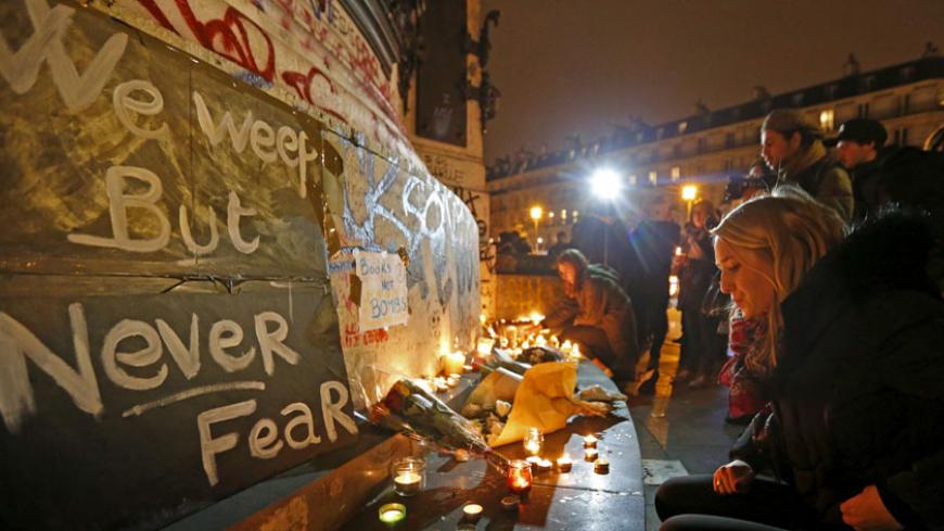 Flowers and candles are placed near the scene of a shooting the day after a series of deadly attacks in Paris, France, November 14, 2015. REUTERS/Yves Herman  - RTS72LB
