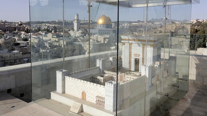 A model depicting the first Jewish temple, which once stood underneath the compound housing the Dome of the Rock (seen centre, in background) and Al-Aqsa mosque, is seen in Jerusalem's Old City June 2, 2015. The compound is known to Muslims as the Noble Sanctuary and to Jews as Temple Mount. Picture taken June 2, 2015. To match Special Report ISRAEL-JERUSALEM/DOME  REUTERS/Ammar Awad  
 - RTX1F1UX
