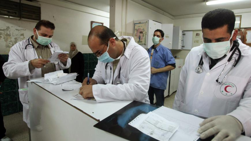 Palestinian doctors wear face masks at the reception of al-Shifa hospital in Gaza City December 6, 2009. H1N1 swine flu has finally reached the Gaza Strip, the health ministry said on Sunday, worrying Palestinians who had credited Israel's blockade of the territory with keeping the virus at bay. REUTERS/Mohammed Salem (GAZA POLITICS HEALTH) - RTXRJIC