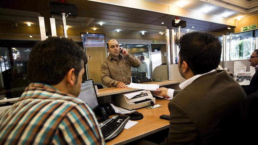An Iranian customer speaks with a bank clerk at the Export Development Bank of Iran in the capital Tehran on July 27, 2015. Iran's central bank chief said that Iran has assets of $29 billion in overseas banks that could be unlocked under a nuclear deal struck on July 14, far less than reported estimates of over $100 billion. AFP PHOTO / BEHROUZ MEHRI (Photo credit should read BEHROUZ MEHRI/AFP/Getty Images)