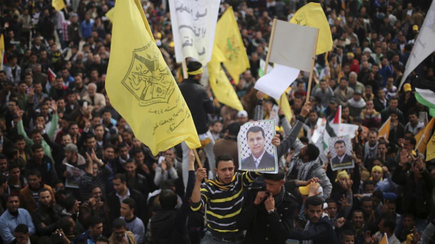 A Palestinian supporter of former head of Fatah in Gaza, Mohammed Dahlan, holds a poster depicting Dahlan during a protest against Palestinian President Mahmoud Abbas in Gaza City December 18, 2014. Dahlan, who lives in exile in the Gulf, is a powerful political foe of Abbas. 
REUTERS/Mohammed Salem (GAZA - Tags: POLITICS CIVIL UNREST) - RTR4IJ83