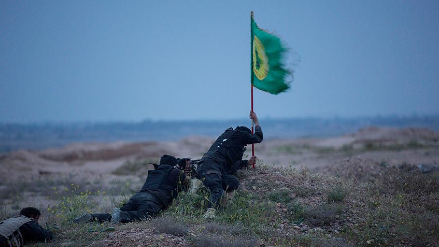 Shi'ite fighters, known as Hashid Shaabi, clash with Islamic State militants, as one tries to put a Shi'ite flag in the ground, in northern Tikrit, March 12, 2015. Iraqi security forces and mainly Shi'ite militia fought Islamic State fighters in Tikrit on Thursday, a day after they pushed into Saddam Hussein's home city in their biggest offensive yet against the militants. Picture taken March 12, 2015. REUTERS/Stringer (IRAQ - Tags: POLITICS CIVIL UNREST CONFLICT) - RTR4T6WJ