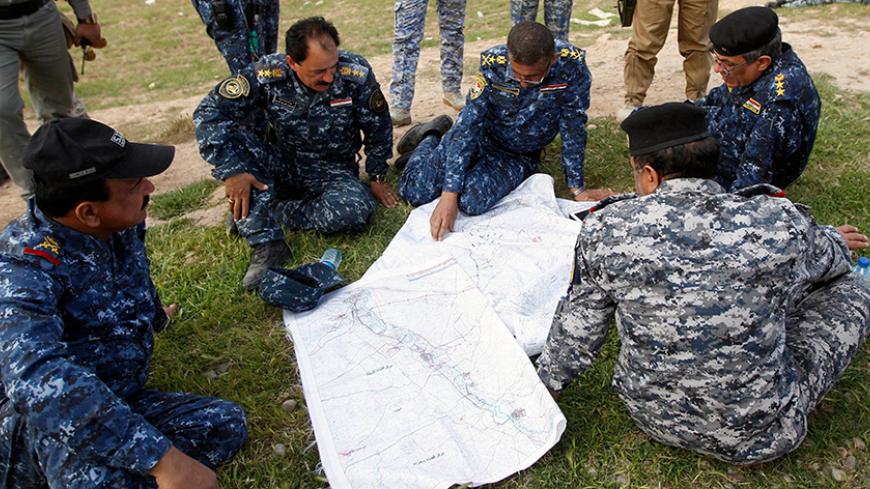 Iraqi officers inspect a map on the outskirts of al-Alam March 8, 2015. REUTERS/Thaier Al-Sudani (IRAQ - Tags: MILITARY CIVIL UNREST CONFLICT)
Thaier Al-Sudani: "It was me and a few other Iraqi journalists working for local outlets. We went to the frontlines in coordination with the Iraqi government forces and supporting militias.
The press officer would come in the morning and take us to the frontline in a convoy.
Whenever an area was won from Islamic State, the fighters would chant and pray and sho