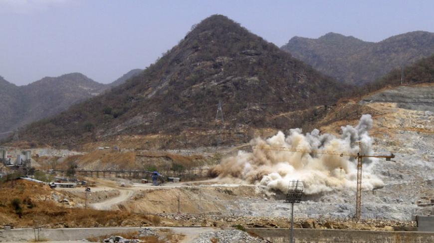 A cloud of dust rises from a dynamite blast, as part of construction work, at Ethiopia's Grand Renaissance Dam during a media tour along the river Nile in Benishangul Gumuz Region, Guba Woreda, in Ethiopia March 31, 2015. According to a government official, the dam has hit the 41 percent completion mark. Picture taken March 31, 2015. REUTER/Tiksa Negeri  - RTR4VQ69