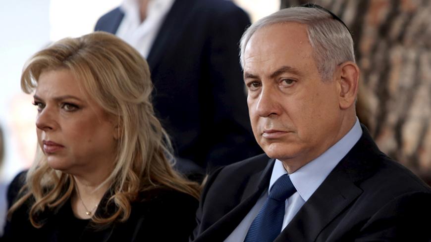 Israeli Prime Minister Benjamin Netanyahu sits with his wife Sara during the state funeral ceremony of Israel's former president Yitzhak Navon at the Mt. Herzl Cemetery in Jerusalem November 8, 2015. REUTERS/Gali Tibbon/Pool - RTS612E
