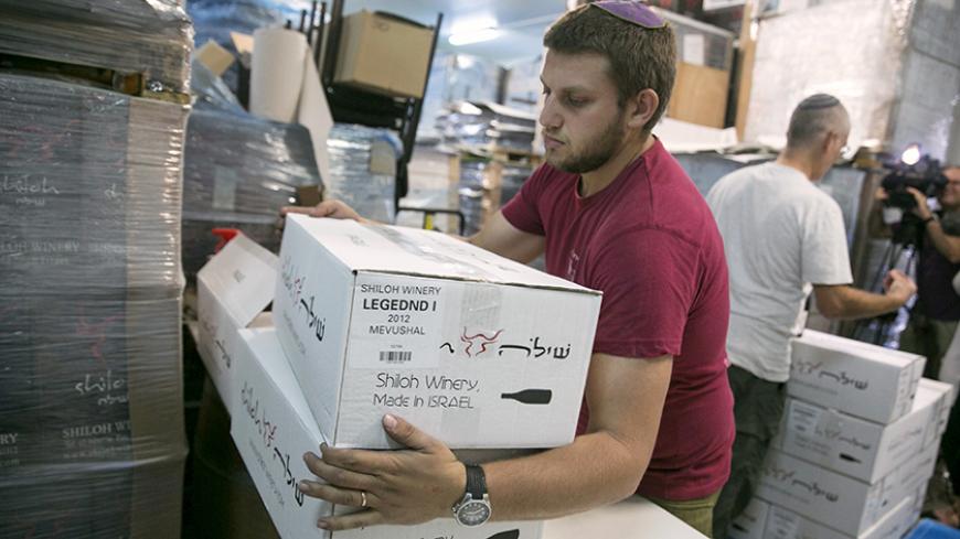 A worker carries boxes containing wine bottles for export at Shiloh Wineries, north of the West Bank city of Ramallah November 8, 2015. Few issues have caused more friction between Israel and the European Union than EU plans to impose labeling on goods produced in Jewish settlements on occupied land. And if Israel is right about the timing, the tensions could get worse." Shiloh Wineries, which exports half of the more than 100,000 bottles of wine it produces annually, built its business around its West Bank