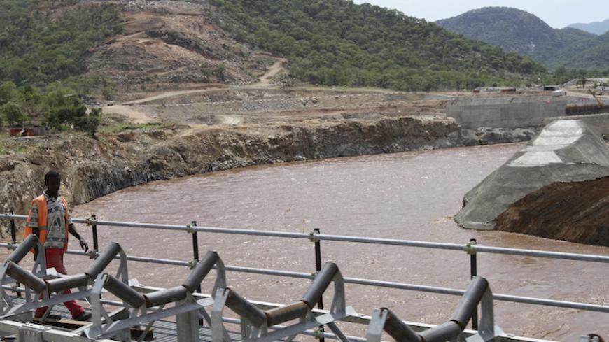 A man walks over a bridge by the construction of Ethiopia's Great Renaissance Dam in Guba Woreda, some 40 km (25 miles) from Ethiopia's border with Sudan, June 28, 2013. Egypt fears the $4.7 billion dam, that the Horn of Africa nation is building on the Nile, will reduce a water supply vital for its 84 million people, who mostly live in the Nile valley and delta. Picture taken June 28, 2013. REUTERS/Tiksa Negeri (ETHIOPIA - Tags: POLITICS SOCIETY ENERGY ENVIRONMENT) - RTX115K9