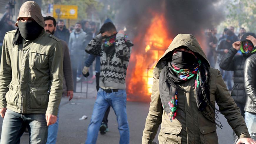 Demonstrators cover their faces as they clash with riot police during a protest against the curfew in Sur district, in the southeastern city of Diyarbakir, Turkey, December 14, 2015. Turkish police fired tear gas and water cannon to disperse a protest against a security crackdown in the main southeastern city of Diyarbakir on Monday, witnesses said, while curfews were declared elsewhere in the region. Turkey's mainly Kurdish southeast has been beset by unrest in recent months as security forces battle Kurdi