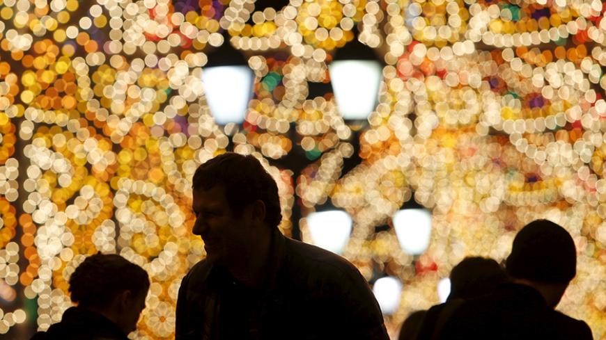 People gather in a street decorated with festive illumination lights, part of the New Year and Christmas holidays celebration, in central Moscow, Russia, December 21, 2015. REUTERS/Maxim Shemetov - RTX1ZNBA